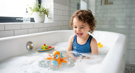 Ein Kind spielt fröhlich mit einem Schwimmer zum Aufziehen für Badespass in der Badewanne und im Pool für alle Kinder